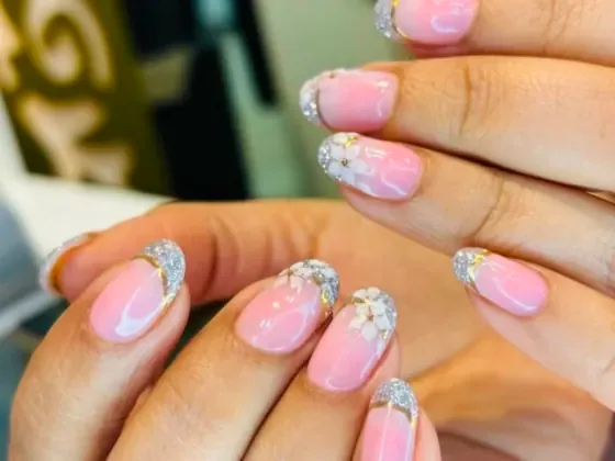 Pink ombre French nails with gold trim and hand-painted flowers